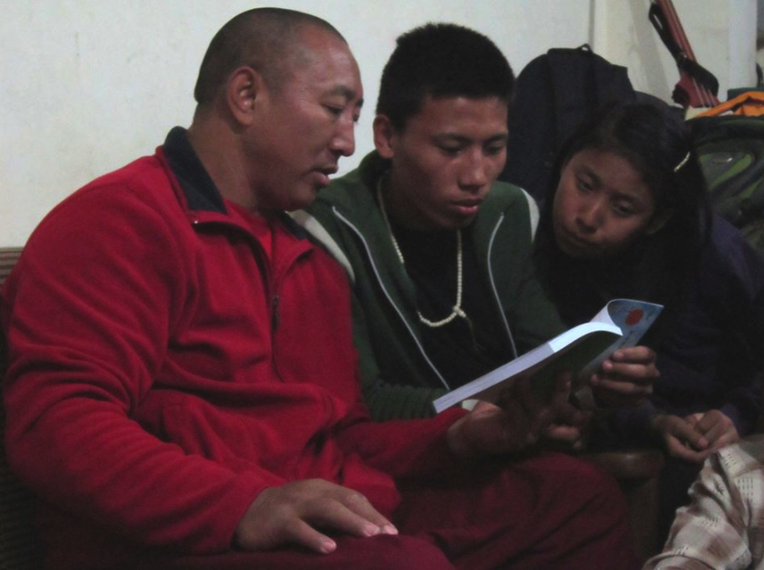 Manager Lama Tenzing helping Dhonyoun Gyalpo read a new Tibetan book from Lhasa.