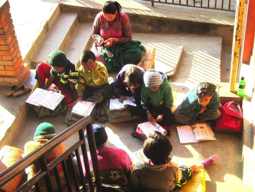 Kids at the home studying in a sunlit stairwell.